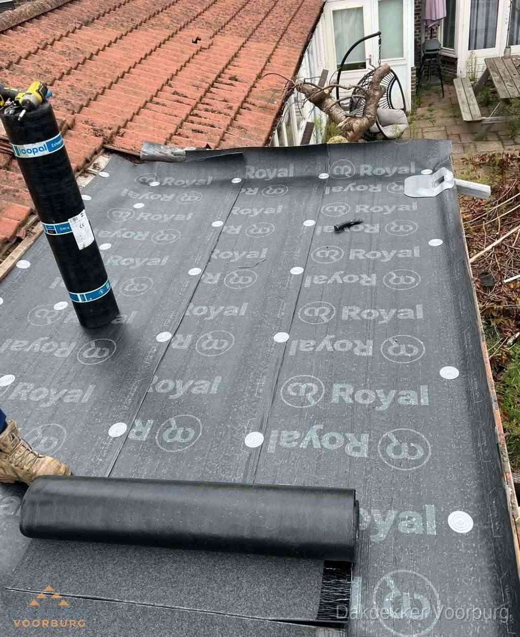 Plat dak met nieuwe bitumen dakbedekking en brandgereedschap in Voorburg