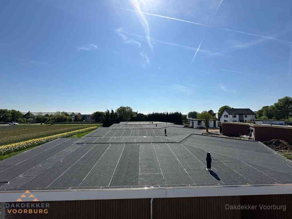 Groot plat dak met bitumen dakbedekking op bedrijfspand in Voorburg