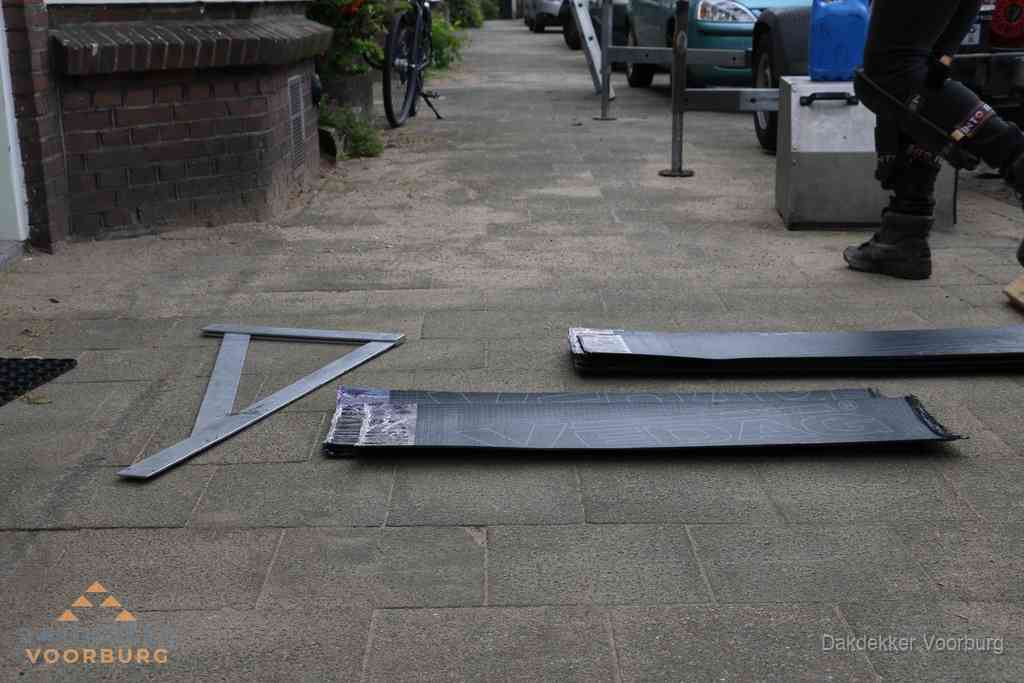 Dakbedekkingsmateriaal en zinkwerk klaargelegd voor reparatie in Voorburg