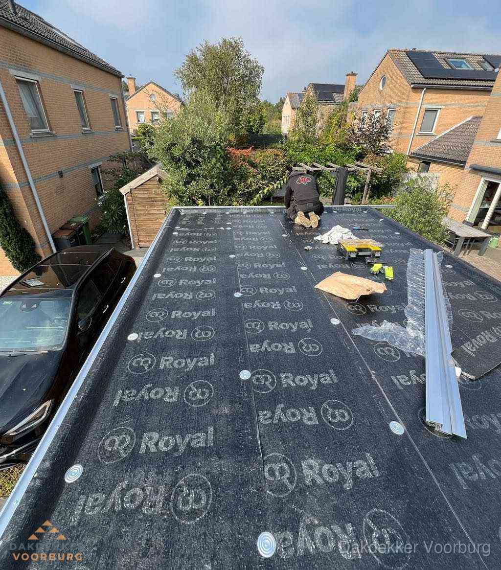 Dakdekker aan het werk op plat dak renovatie in Voorburg