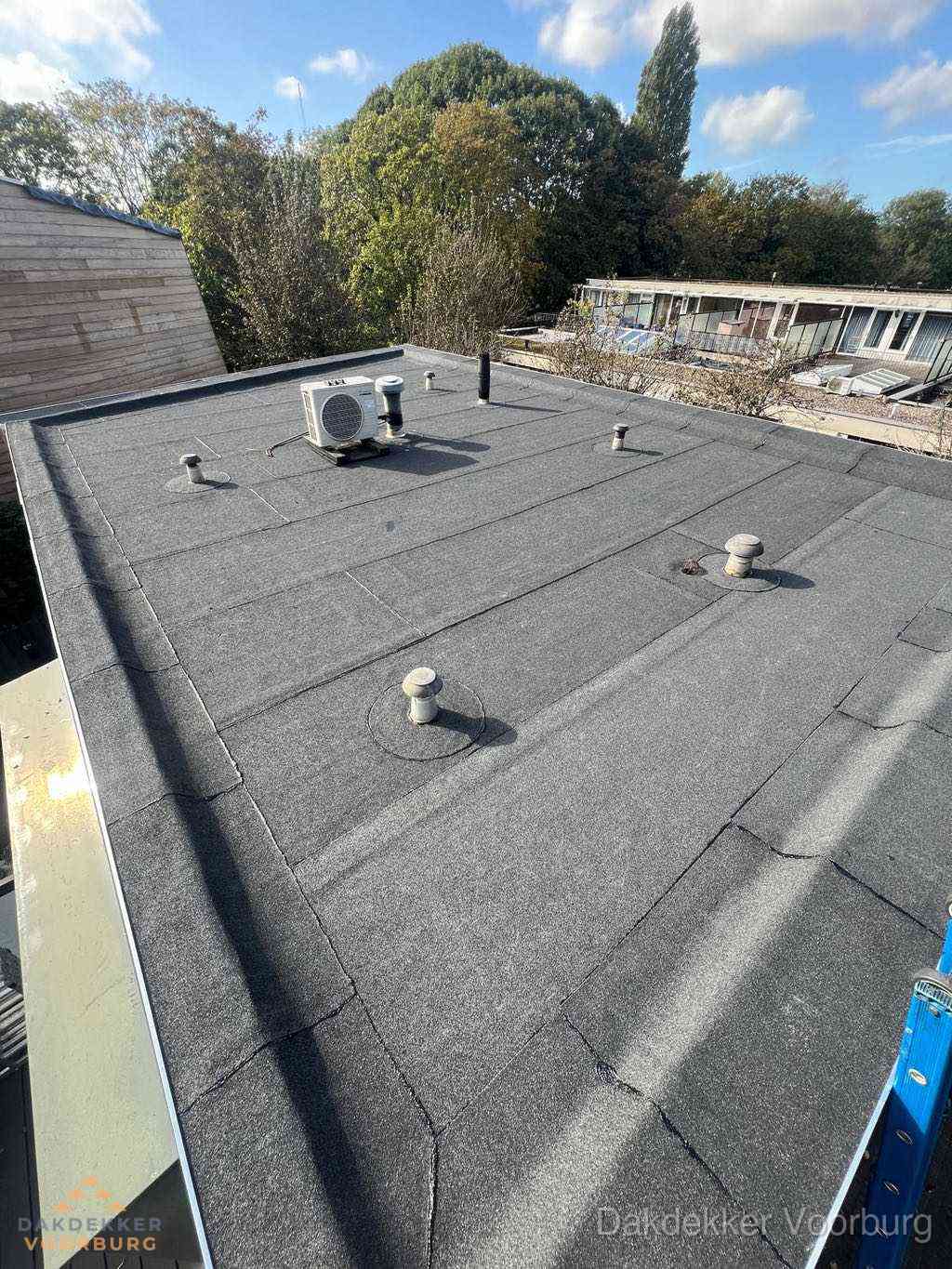 Plat dak met bitumen en brandgereedschap van dakdekkersbedrijf in Voorburg