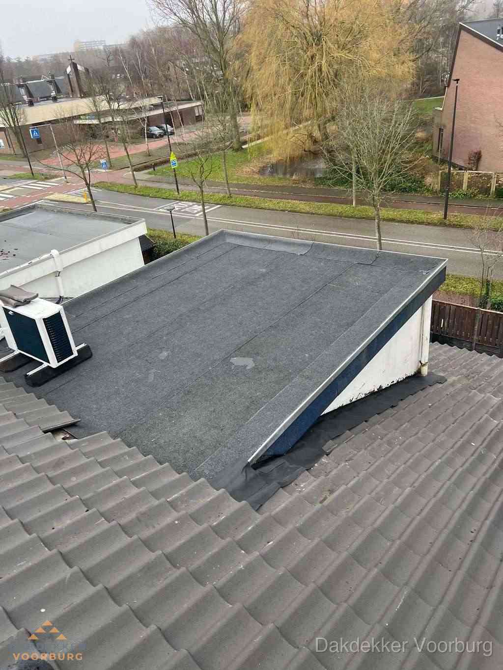 Plat dak met bitumen dakbedekking naast schuin pannendak in Voorburg