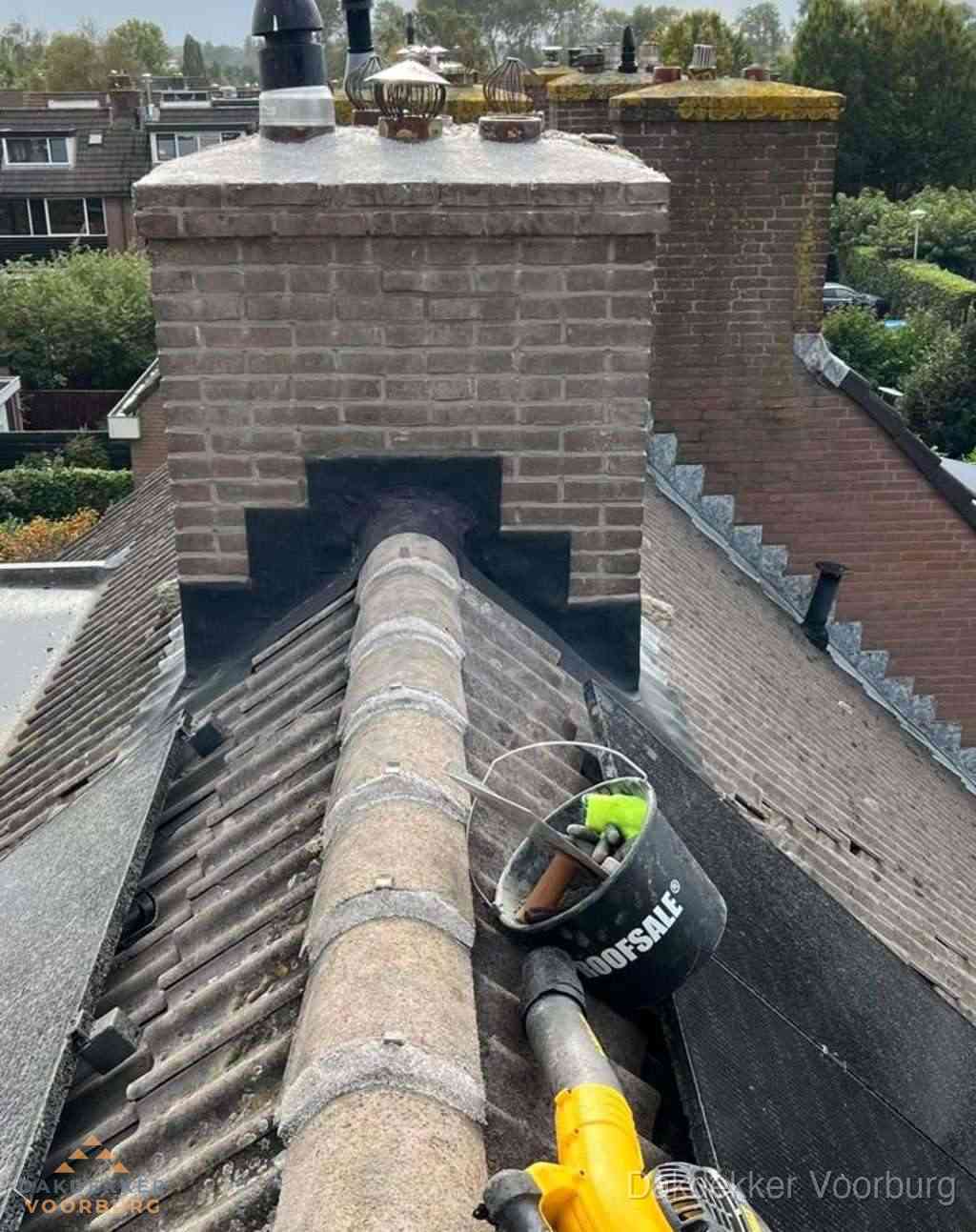Dakdekker repareert bitumen dakleer bij dakdoorvoer in Voorburg